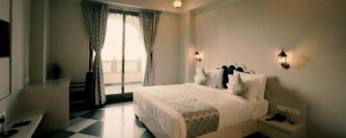 乌代浦The Biletha Bagh的卧室配有白色的床和窗户。