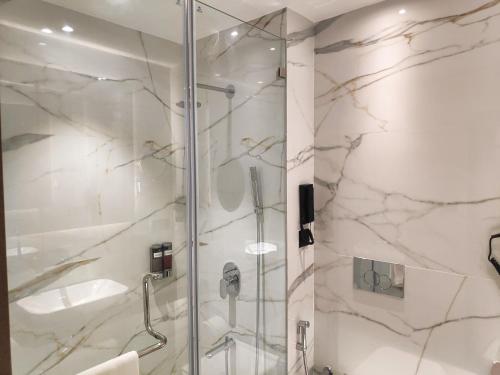 孟买Maxxvalue Hotel MIDC - Andheri的浴室里设有玻璃门淋浴