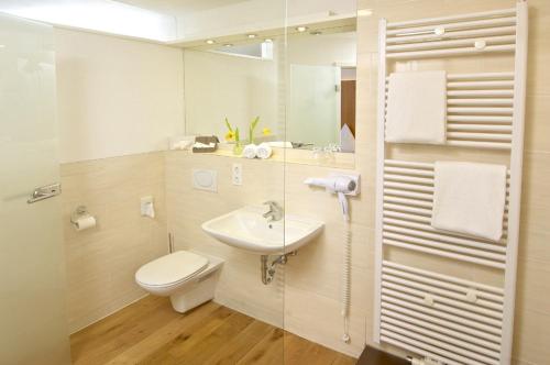 魏勒-锡默贝格帕斯特酒店的白色的浴室设有水槽和卫生间。