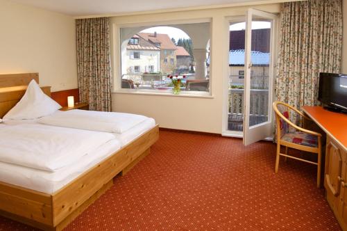 魏勒-锡默贝格帕斯特酒店的一间卧室配有一张床、一张书桌和一个窗户。