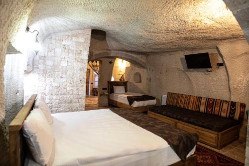 格雷梅Avilla Cave Hotel的一间卧室配有两张床,卧室内配有沙发