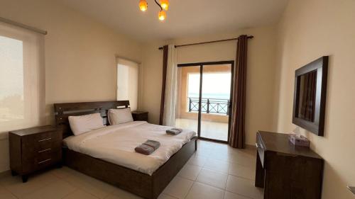 索瓦马E25 Samarah Resort Apartments的一间卧室设有一张床,享有海景