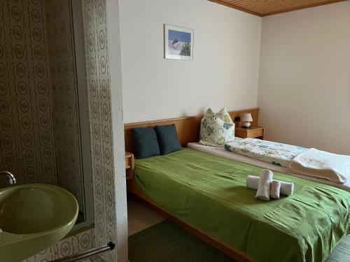 Lenche Gasthaus Neumayer的一间卧室配有一张床,浴室设有水槽