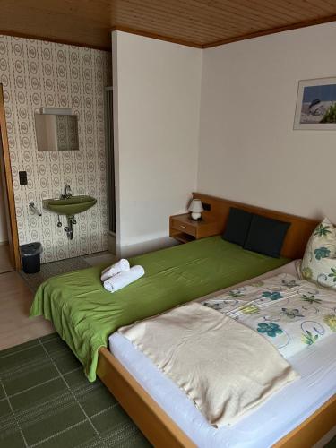 Lenche Gasthaus Neumayer的一间卧室配有一张带绿毯的大床