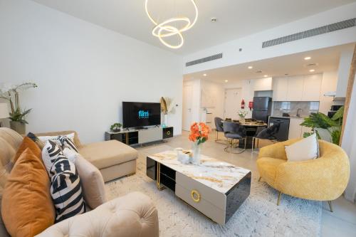 迪拜FAM Living - Serene 1BR Haven in Madinat Jumeirah Living的带沙发、电视和桌子的客厅