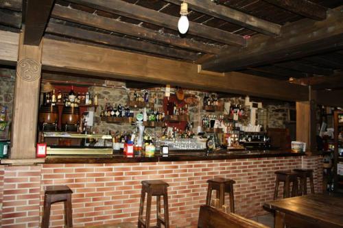 CampomanesHotel Rural El Reundu的一间有砖墙的酒吧,还有一些酒吧凳