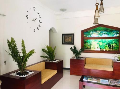 康提Kandy City Village的一间配有沙发和墙上时钟的等候室