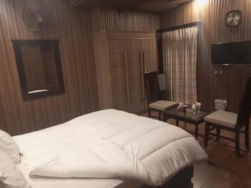费萨拉巴德silk.hotel的卧室配有白色的床和桌椅