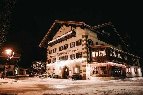 罗孚尔Hotel - Wirts'haus "Zum Schweizer"的一座大建筑物,在晚上下雪