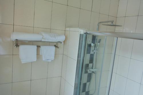 利隆圭Divine Heights Apartments Lilongwe Area 43的一间带白色毛巾和淋浴的浴室