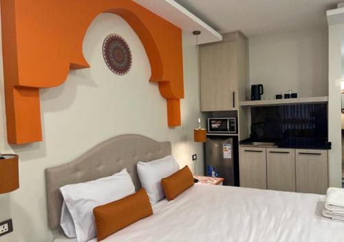 安曼Amman Trail Hotel & Studios的一间卧室配有一张橙色色调的大型白色床。
