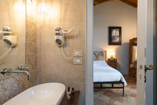 林瓜格洛萨Casa Arrigo的一间带浴缸和水槽的浴室以及一间卧室
