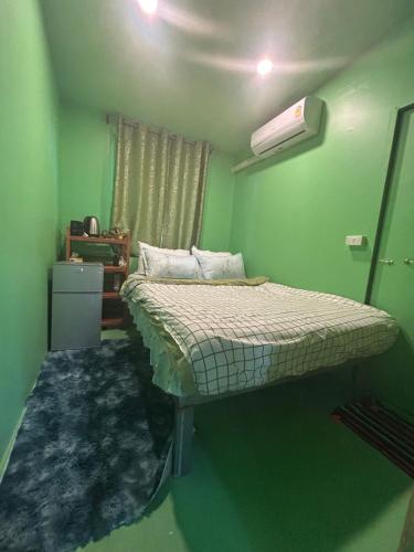 帕干岛Simple Garden Resort的一间位于绿色客房内的卧室,配有一张床