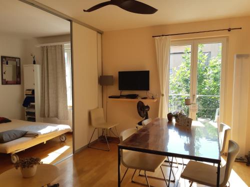 苏黎世Central quiet and cosy apartment near Hallenstadion的客厅配有餐桌和电视