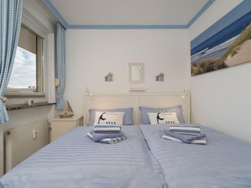 韦斯特兰Appartement Strandnah的一间卧室配有一张带两个枕头的床