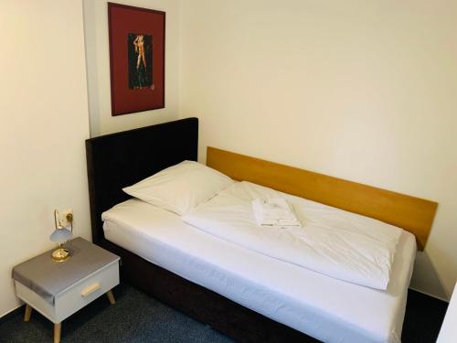 日利纳斯洛文酒店的一间卧室配有一张带白色床单和一张桌子的床。