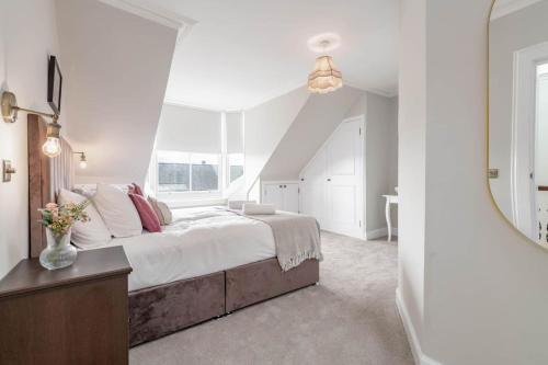 圣安德鲁斯Skye Sands - 11 Alexandra Penthouse - St Andrews的白色卧室设有一张大床和镜子