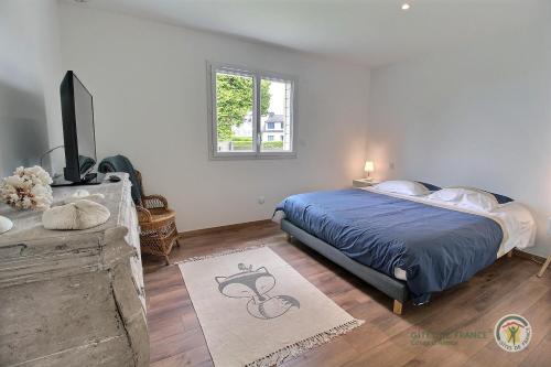 普勒默尔博杜La maison du golf的一间卧室配有一张床和一台平面电视