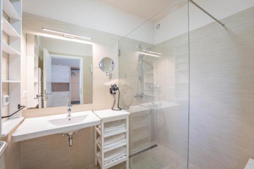 斯拉Appartements Thermen-Golfresort Pannonia的一间带水槽和玻璃淋浴的浴室