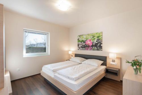 斯拉Appartements Thermen-Golfresort Pannonia的白色的卧室设有床和窗户