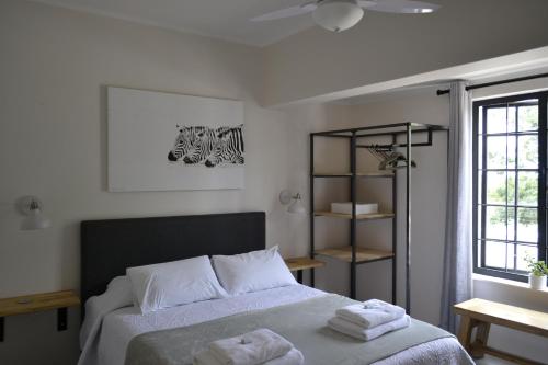 比勒陀利亚Zebra Cottage - House - Backup Power - Fast WIFI的一间卧室配有一张床,上面有两条毛巾