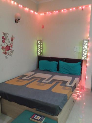 诺伊达Home Stay 1的一间卧室配有一张灯光床