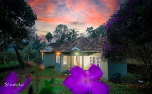ViriparaBreeze Hill resort的一座小房子前面有紫色的鲜花