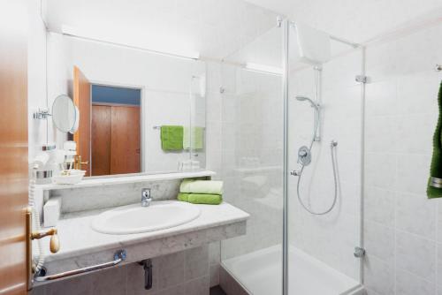 罗伊特苏姆莫伦酒店的白色的浴室设有水槽和淋浴。