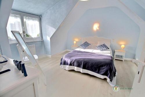 普卢巴拉内克Le ploubaz的一间卧室配有一张带紫色棉被的床