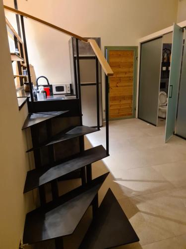 Beʼer OraDesert view studio的螺旋楼梯,位于带门的厨房