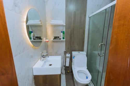 基加利Ibi Villa Retreat的一间带卫生间、水槽和镜子的浴室