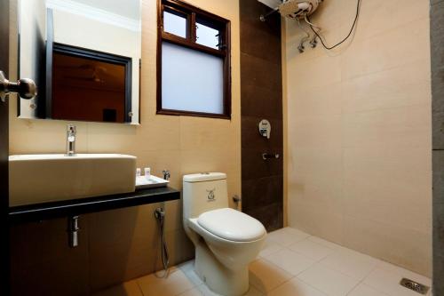 新德里LA SAPPHIRE HOTEL & RESTUARANT的一间带卫生间、水槽和窗户的浴室