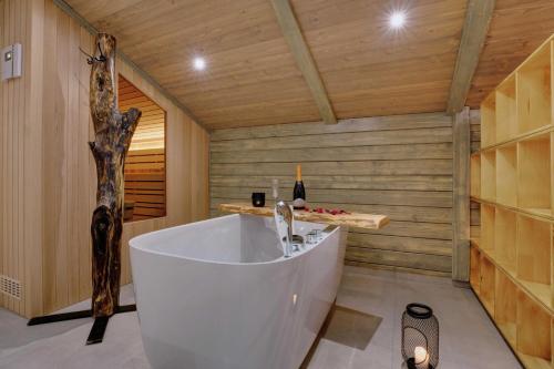 拉什科Apartment Hanny的木墙客房内设有带大浴缸的浴室