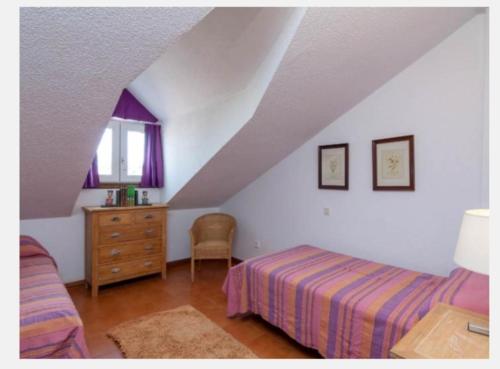 擞莫Somo Calle Ria Cubas的一间卧室配有一张床、一个梳妆台和一扇窗户。
