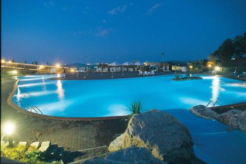 圣马力诺Centro Vacanze San Marino的一座晚上点亮的大型游泳池