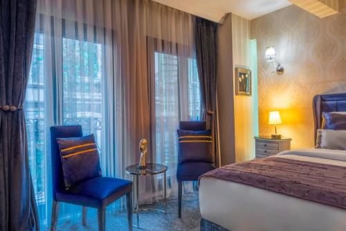 伊斯坦布尔In Pera Boutique Hotel的酒店客房带床、椅子和窗户