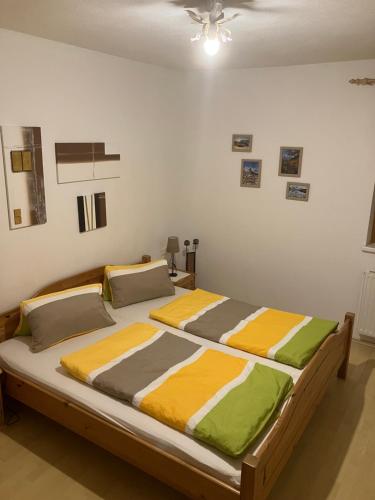 海因岑贝格Appartement Ramona的一间卧室配有一张带黄色和绿色床单的大床