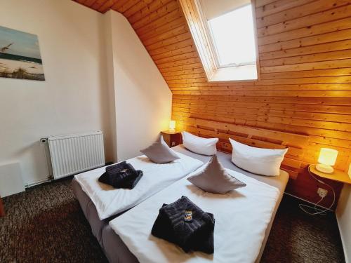 巴斯托夫Küstenhaus Fewo klein的木墙客房的两张床