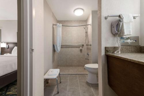 杰克逊维尔Quality Inn Orange Park Jacksonville的带淋浴和卫生间的浴室以及1张床。