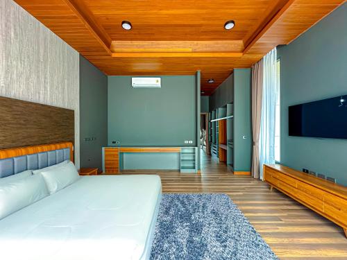 普吉镇Villa Menara Bang Tao的一间卧室配有一张床和一台平面电视