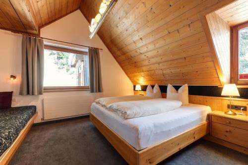 圣安东阿尔贝格科施广场膳食公寓酒店的卧室设有一张木制天花板上的大床
