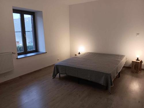 Saint-Michel-sur-MeurtheGîte des Sagards的一间带一张大床的卧室,位于带两盏灯的房间