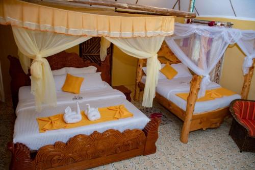 OlolaimutiekEco Mara Tented Camp的配有天蓬床的客房内的两张床