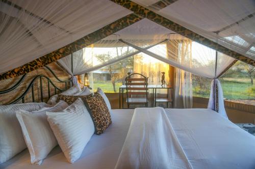 塞伦盖蒂Ndoto Serengeti Camp的帐篷内一间卧室,配有一张床