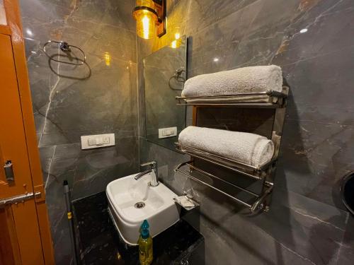 卡索尔Hotel Mid Orchard Kasol l River Side的一间带水槽和毛巾架的浴室