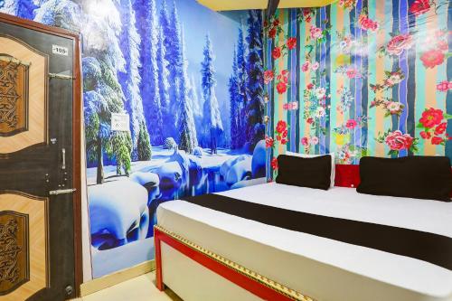 新德里OYO Golden Moment Guest House的卧室配有一张床,并画有树木