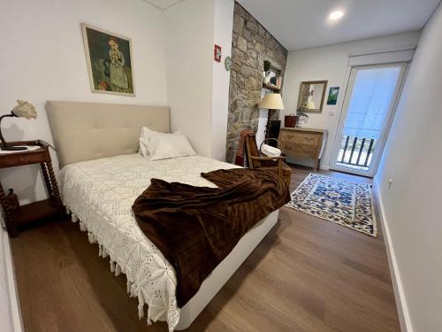 布拉干萨Ninho do Melro II - Turismo Rural Bragança的一间卧室配有一张床铺,床上有毯子