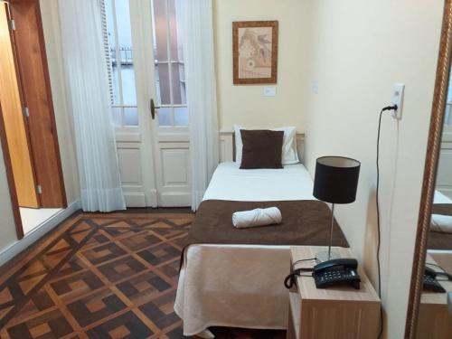 阿雷格里港马特兹广场酒店的小房间设有床和电话