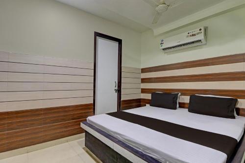 希萨尔Collection O The Legend Hotel, Hisar的一间卧室配有一张带木墙和门的床