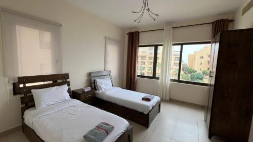 索瓦马E25 Samarah Resort Apartments的酒店客房设有两张床和窗户。